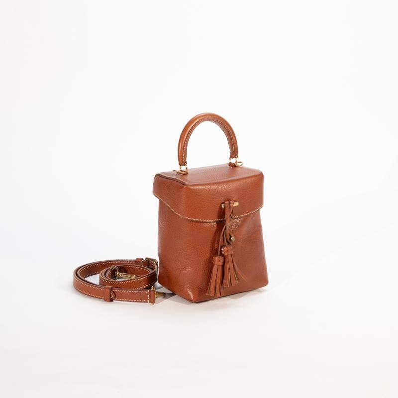 Como o couro curtido vegetal se combina com a estética vintage nesta nova coleção de bolsas?